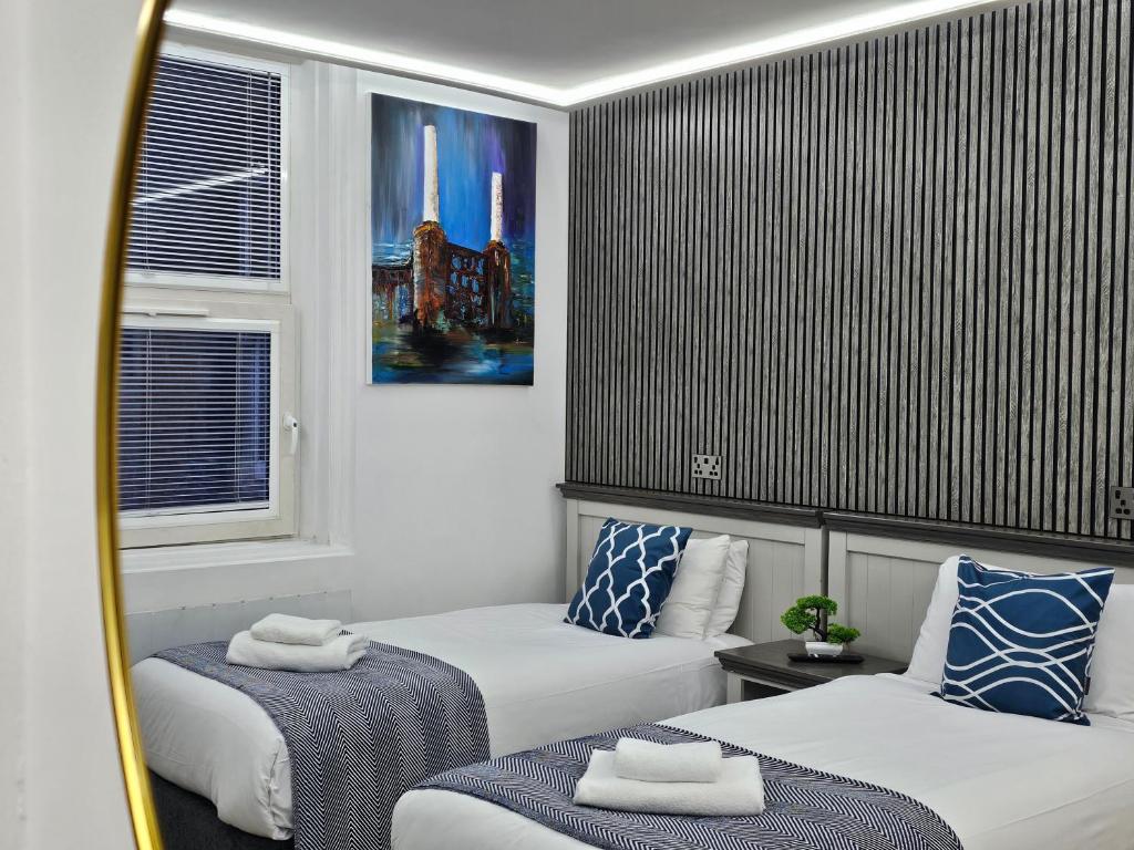 um quarto de hotel com duas camas e uma janela em London Stay Apartments em Londres