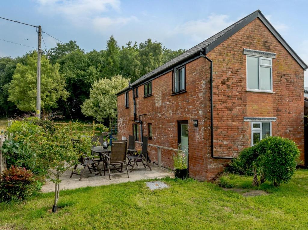 a brick house with a patio and a table at 3 Bed in Wellington 78595 in Sampford Arundel
