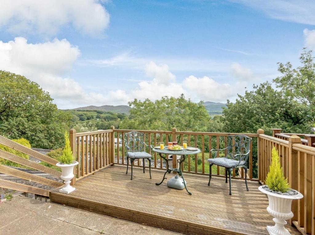 a wooden deck with a table and chairs on it at 1 Bed in Porthmadog 78300 in Penrhyndeudreath