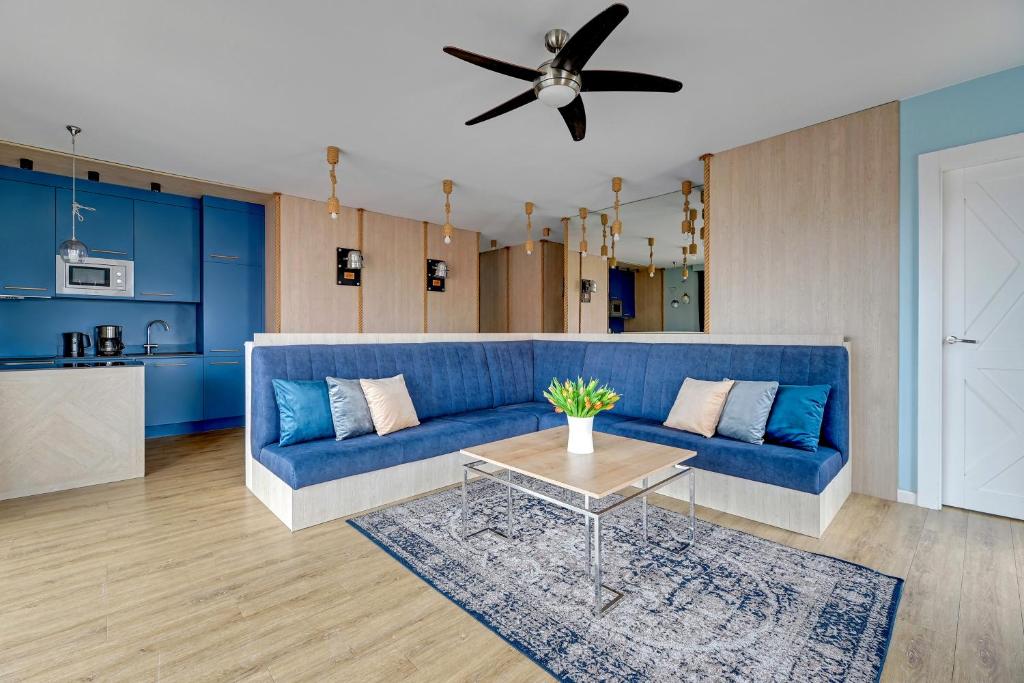 a living room with a blue couch and a table at Staywin Prime Apartments Chmielna in Gdańsk