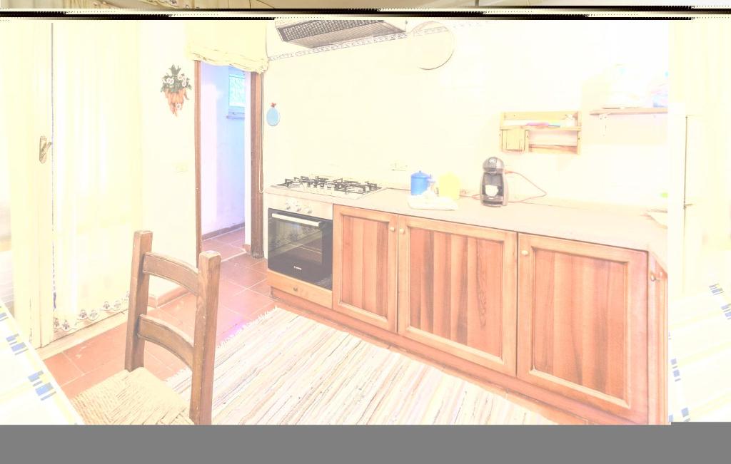 a kitchen with a stove and a chair in it at Villa Antica in Stalettì