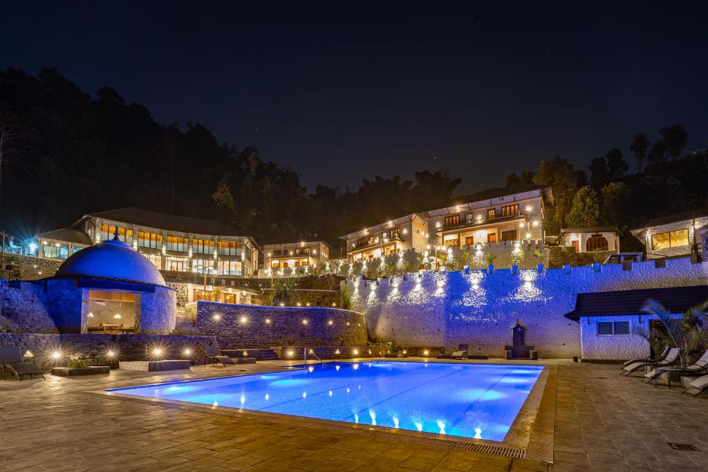 um resort com uma grande piscina à noite em Purna em Pokhara