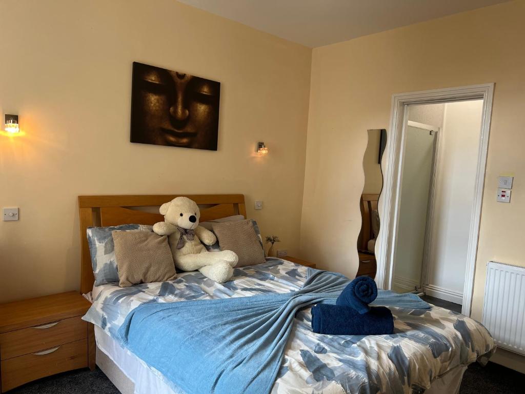a teddy bear sitting on a bed in a bedroom at Winter Gardens Large Flat 1 in Blackpool
