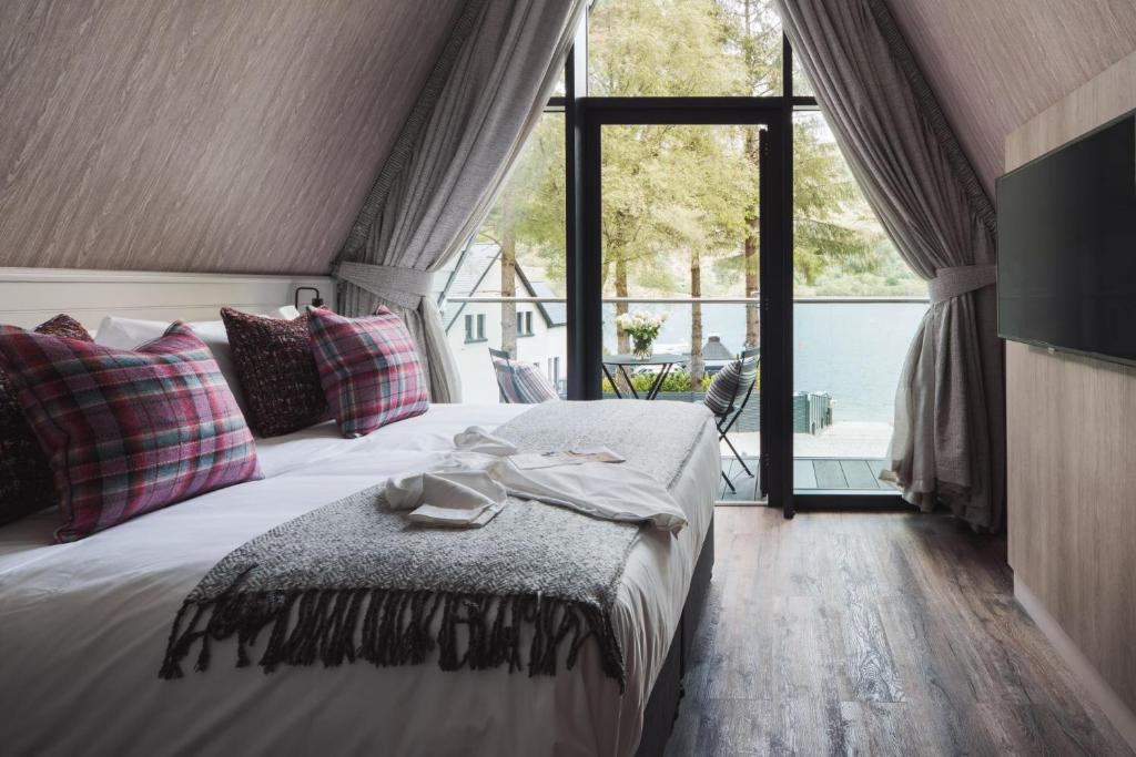 een slaapkamer met een bed en een groot raam bij Ardlui Retreat Lodge 4 in Arrochar