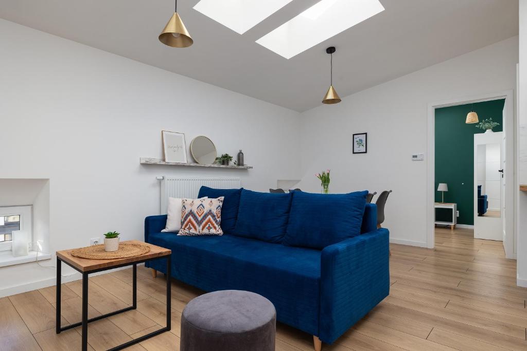a living room with a blue couch and a table at Plac Grunwaldzki Happy Apartment in Szczecin