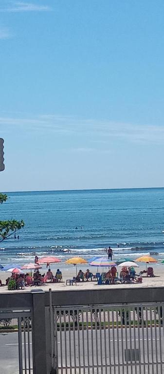 una playa con gente sentada bajo sombrillas en la playa en Amplo apartamento para aluguel diário numa das melhores praias de SC., en Meia Praia
