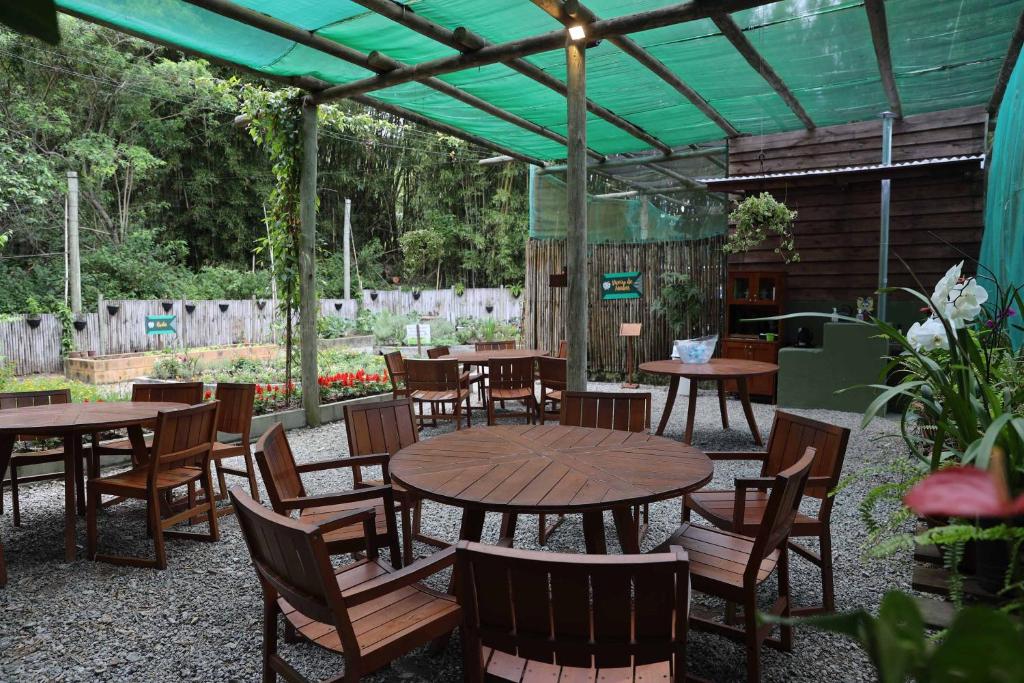 a patio with tables and chairs under a green canopy at Costao do Santinho Resort All Inclusive in Florianópolis