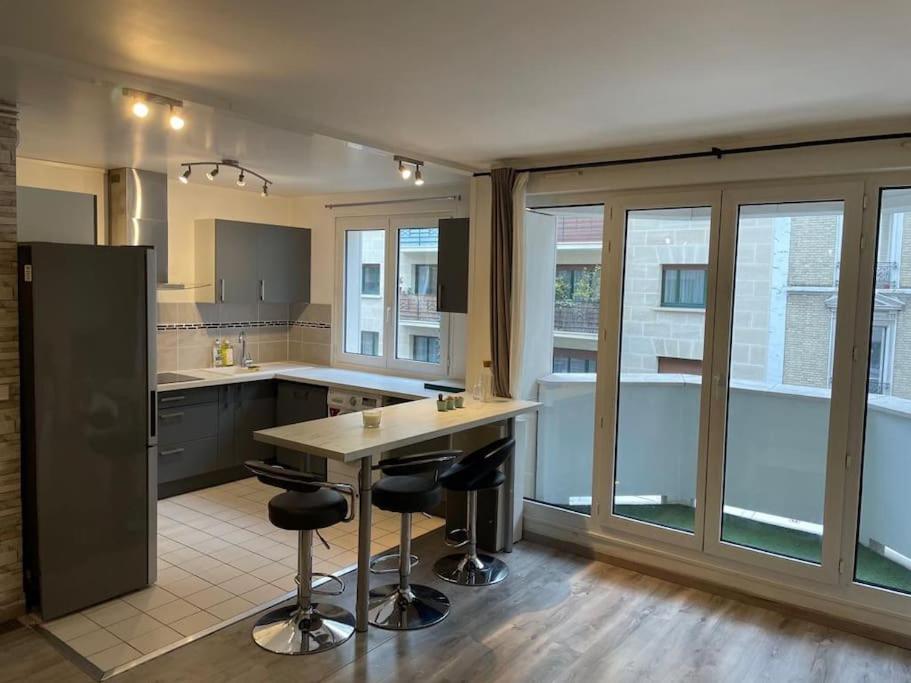 - une cuisine avec un comptoir et des tabourets de bar dans l'établissement Bel Appartement à Bécon, à Asnières-sur-Seine