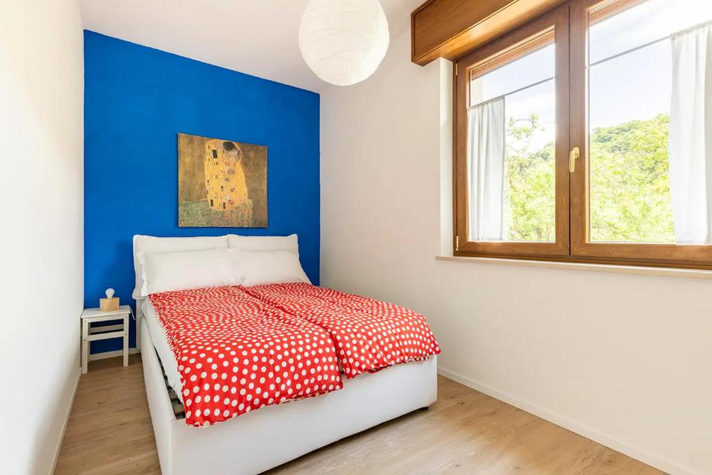 a bedroom with a red and white bed with a window at Dolomiti Relax in Feltre