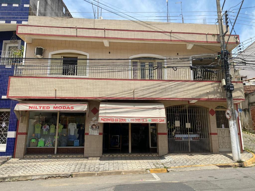 een winkel voor een gebouw in een straat bij Sobrado 5 minutos da Basílica in Aparecida