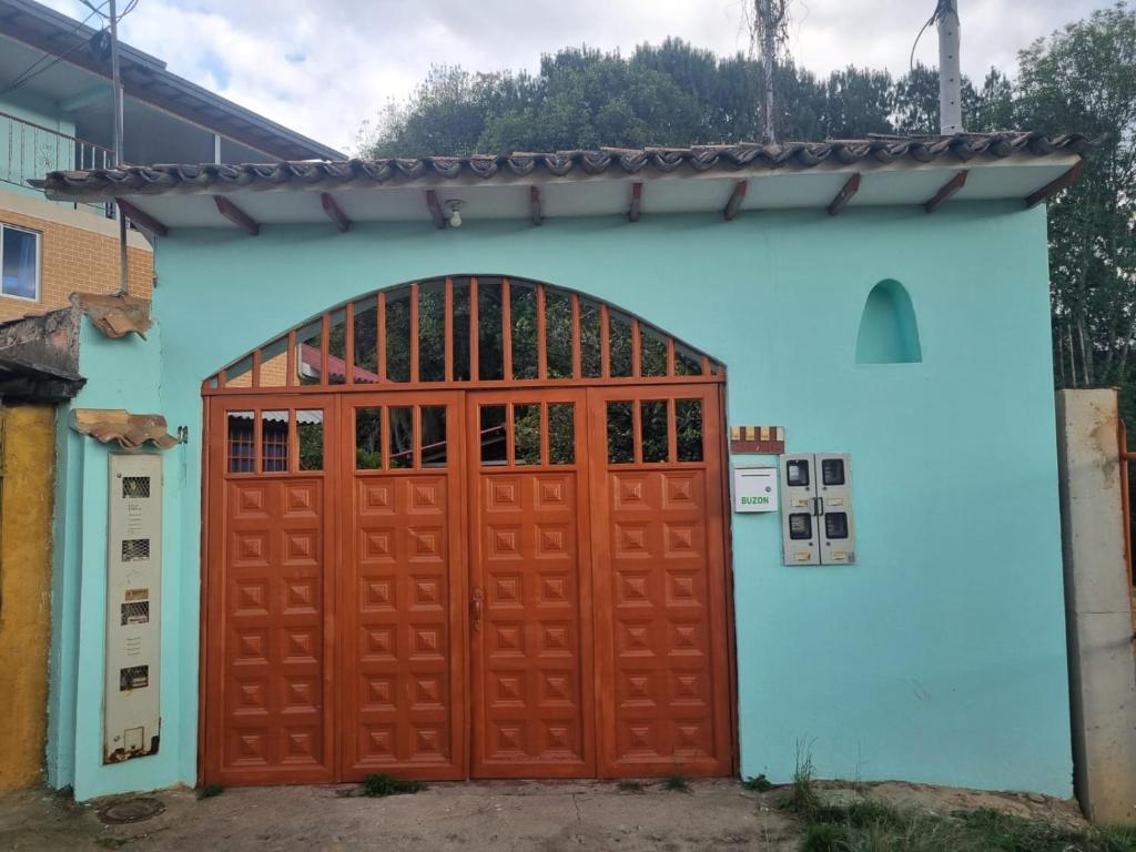eine blaue und orangefarbene Garage mit einer roten Tür in der Unterkunft Hospedaje San Alberto 202-Ráquira in Ráquira