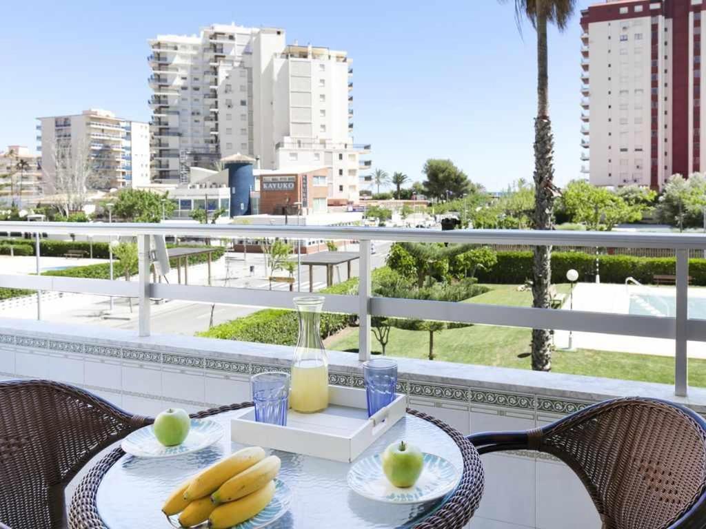 una mesa con plátanos y un vaso de zumo en el balcón en Olimpia playa gandia, en Playa de Gandía