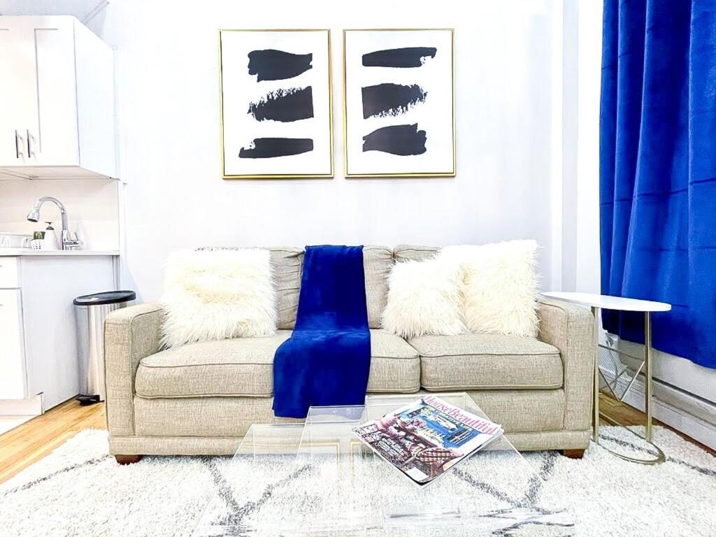 a living room with a couch with a blue blanket at 62-2B Renovated 1BR in Prime Upper East Side in New York