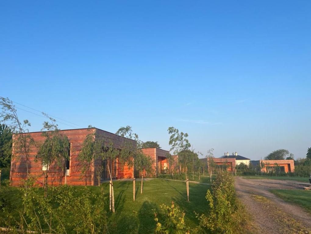 un edificio de ladrillo con un camino de tierra delante de él en Stunning Ashbourne Log Cabin No4, en Ashbourne