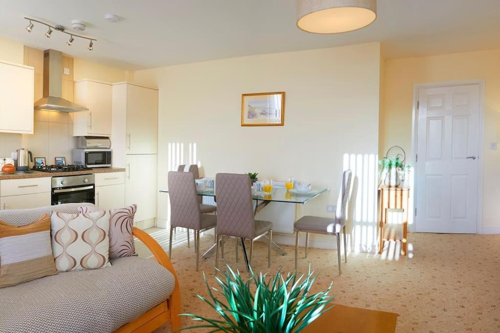 a living room and kitchen with a couch and a table at Ashore@Jubilee in Filey