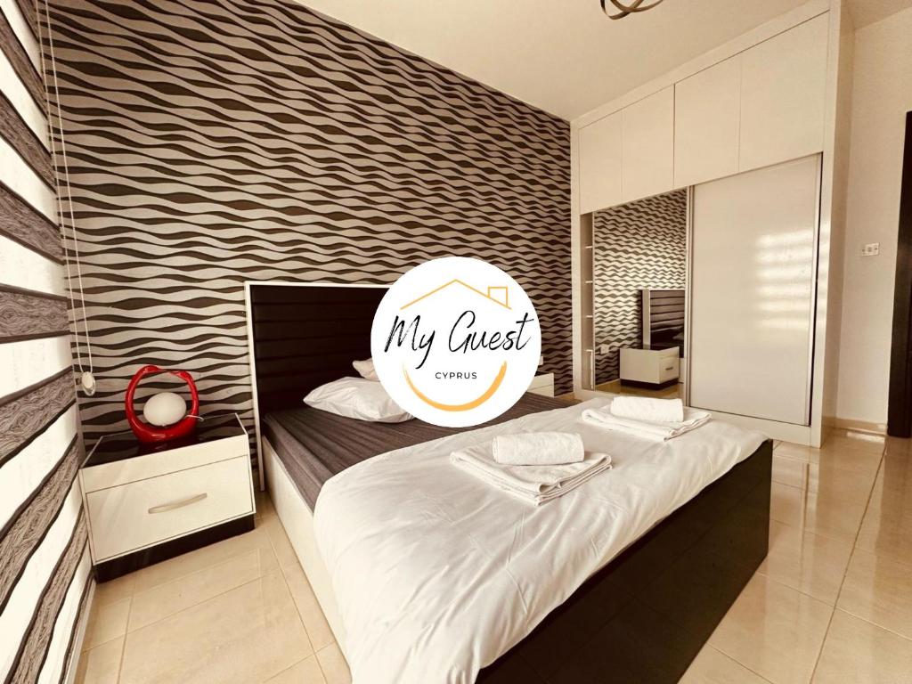 a bedroom with a bed with a sign on it at 2-Bedroom Apartment Pamfilya 7 by MyGuest Cyprus in Famagusta