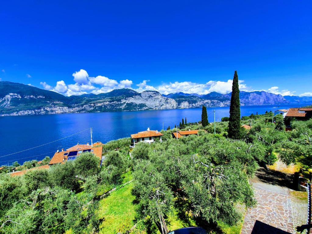 a house on a hill next to a body of water at Casa Valenti in Brenzone sul Garda