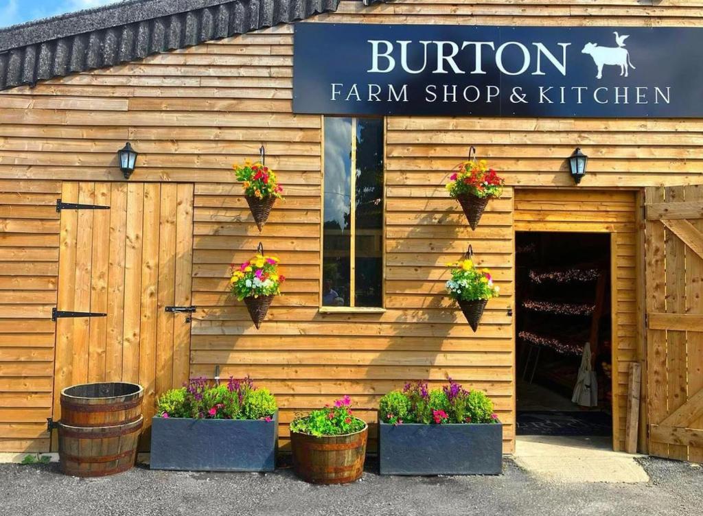 a store with potted plants in front of a building at Luxury Farm Country Retreat in Chippenham