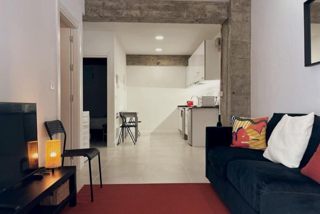 uma sala de estar com um sofá e uma cozinha em Donosti House Hiru con Parking ESS03051 em San Sebastián