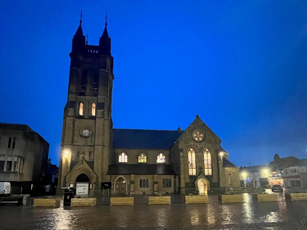 a large church with a clock tower at night at New Derina Hotel in Blackpool