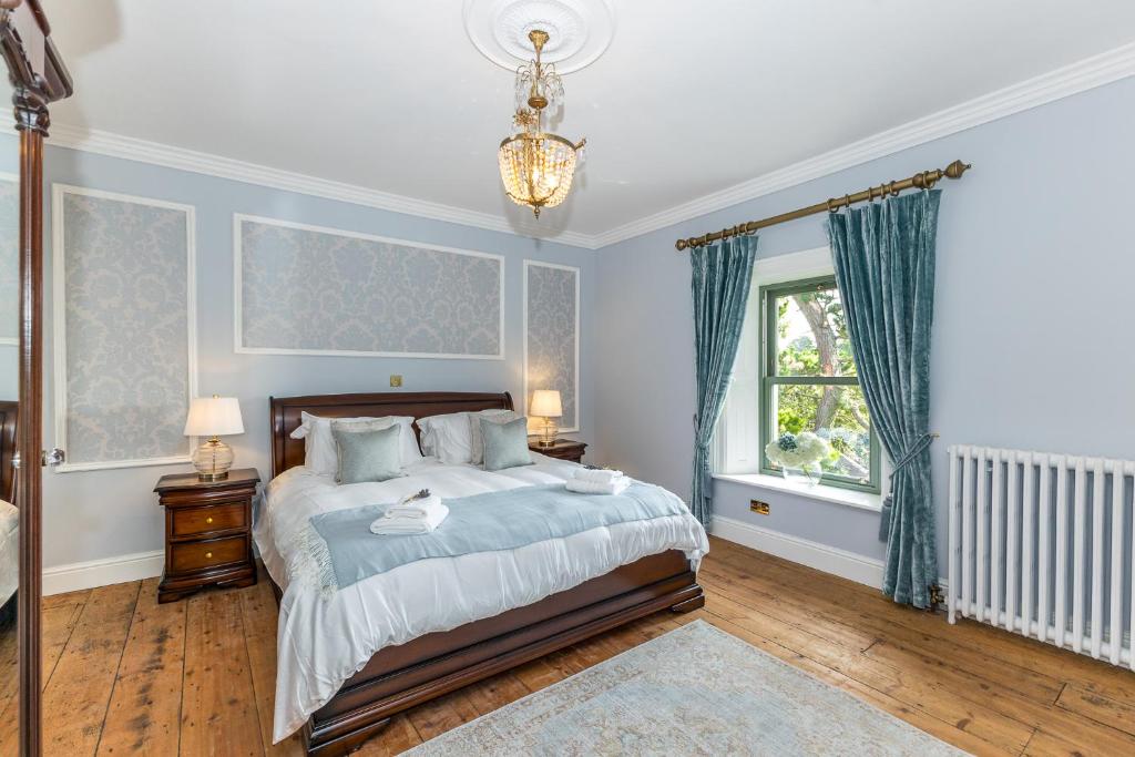 sypialnia z łóżkiem z niebieskimi ścianami i oknem w obiekcie Macepool w mieście Donaghmore