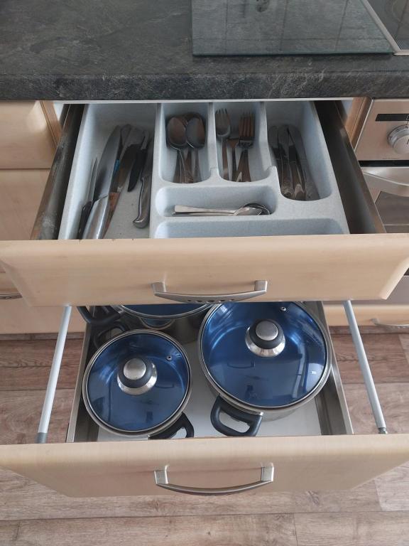 a drawer in a kitchen with blue plates and utensils at Ferienwohnung bis 4 Personen in Hannover in Hannover
