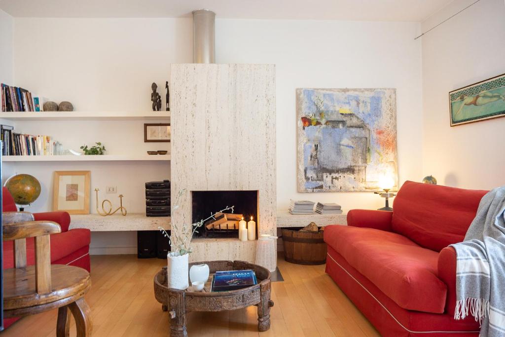 Una sala de estar con un sofá rojo y una chimenea. en Al Cassero, en Perugia