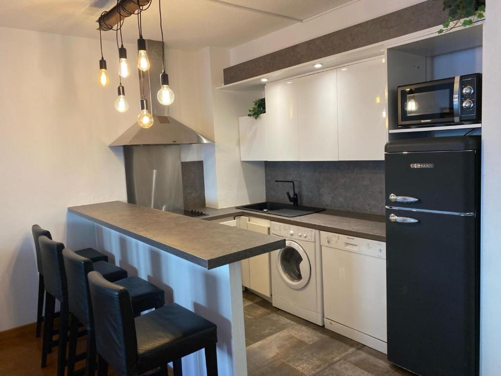 cocina con nevera negra y encimera en SWEET HOME Le 82, en Cannes