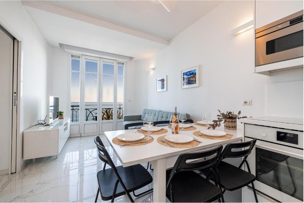 - une cuisine blanche avec une table et des chaises dans l'établissement Sea view - 2 Bdr Promenade des Anglais, à Nice