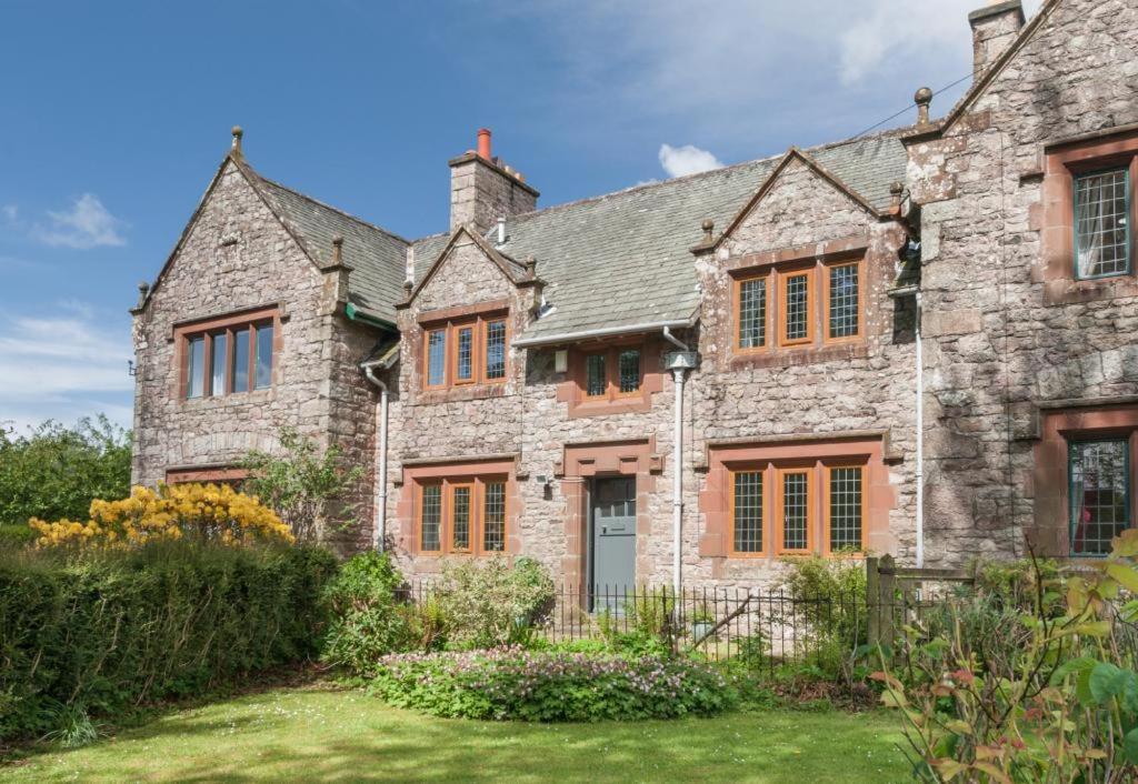 an old stone house with orange windows and a yard at 3 Bed in Eskdale SZ403 in Santon Bridge