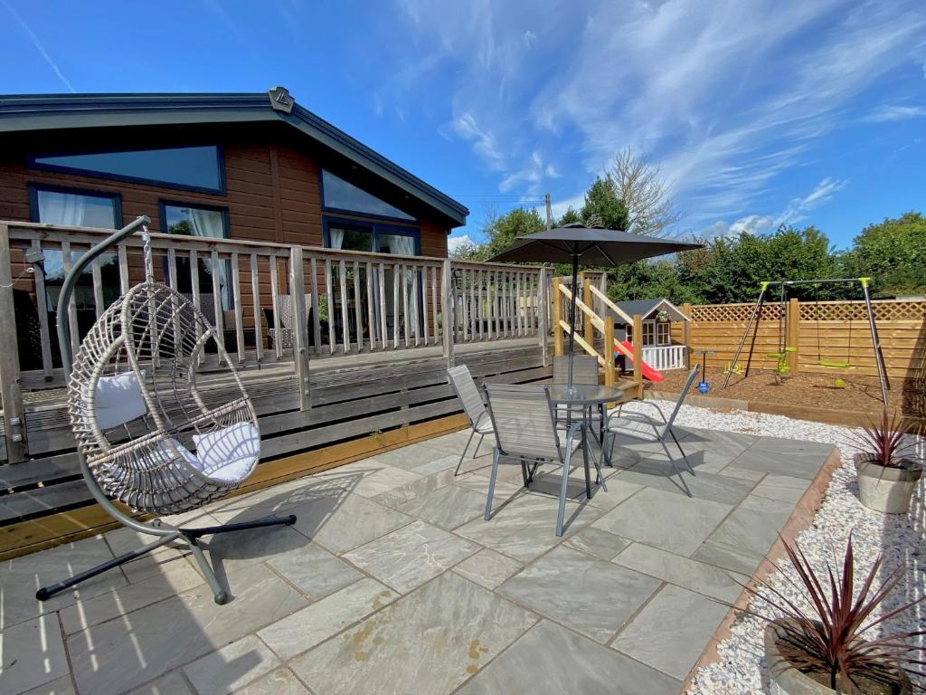 a patio with a table and chairs on a deck at 2 Bed in Sidmouth 76515 in Ottery Saint Mary