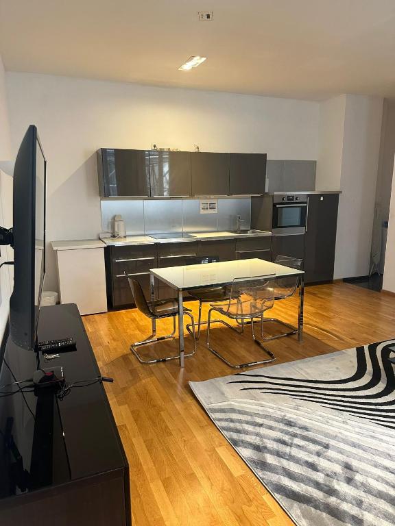 uma cozinha com mesa e cadeiras num quarto em Al Nafurah Apartments em Munique