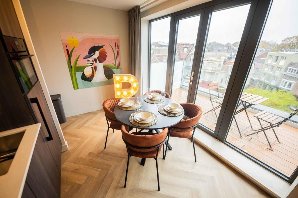 a dining room with a table and chairs and a large window at Studio serviced apartments with City view (KS71-R) in Hilversum