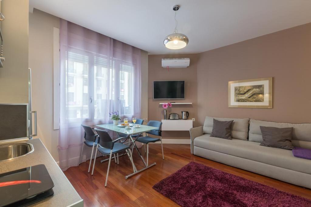 - un salon avec un canapé et une table dans l'établissement Gran Vía 55 Exclusive Apartments, à Madrid