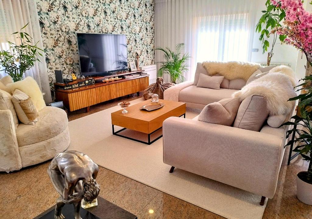 a living room with two couches and a tv at Casa by Anita Guesthouse in Esposende