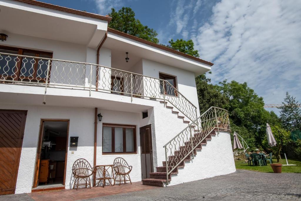 uma casa branca com escadas e uma varanda em Casa maria em Celorio