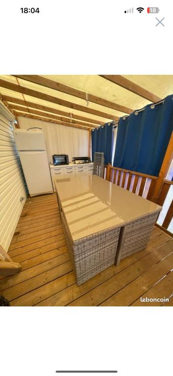 pusty pokój ze stołem i lodówką w obiekcie mobil home numéro 76 w mieście Meschers-sur-Gironde