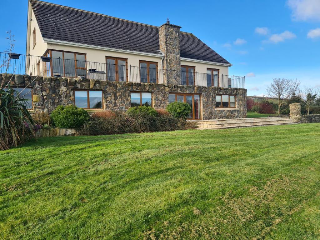 a house with a lawn in front of it at Lakeside House in Ballynahinch