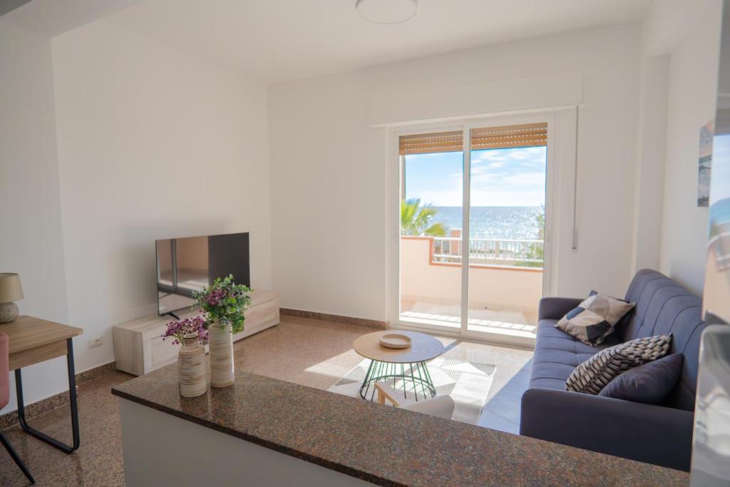 a living room with a blue couch and a television at Casa Erika in Bova Marina