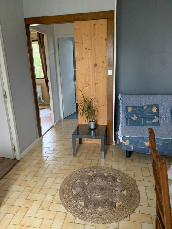 ein Wohnzimmer mit einem blauen Sofa und einem Tisch in der Unterkunft Gîte chez Emy et Seb in Privas