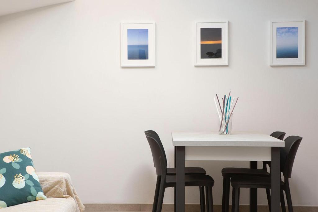 comedor con mesa blanca y sillas en Le case di vada - Il Faro, en Vada