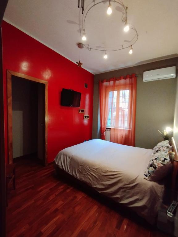 ein Schlafzimmer mit einer roten Wand und einem Bett in der Unterkunft Appartamento dentro Roma in Rom