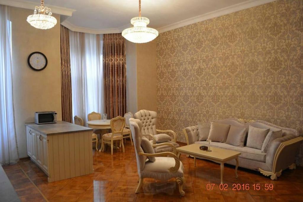 Una sala de estar con un sofá y sillas y una mesa. en Classical apartment in heart of Baku, en Baku