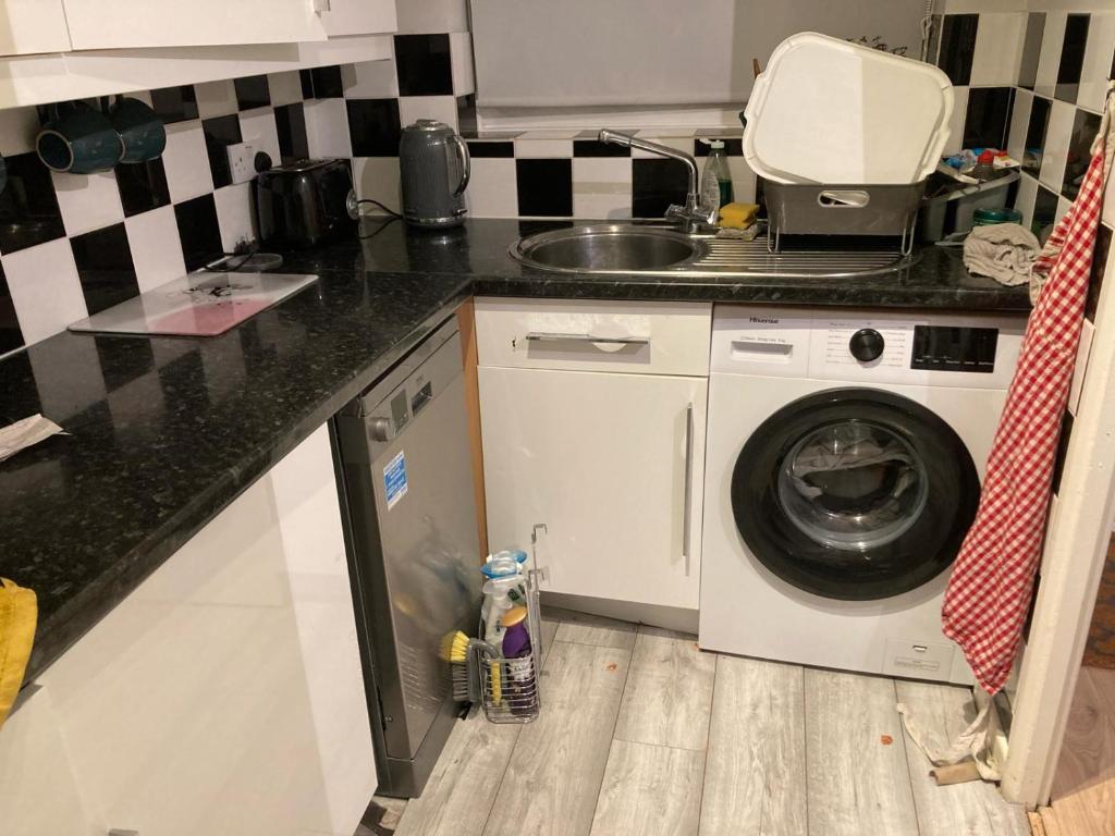 a kitchen with a washing machine and a sink at Ramilies Homes in Chatham