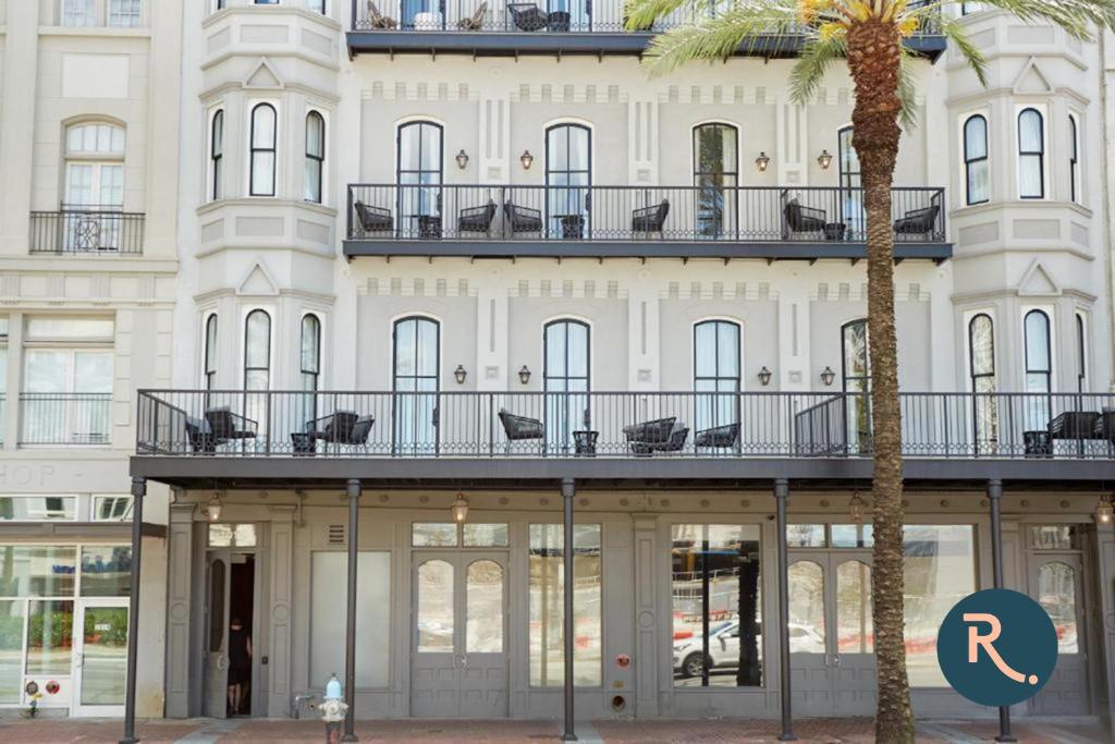 a building with a palm tree in front of it at Roami at Canal Quarters in New Orleans