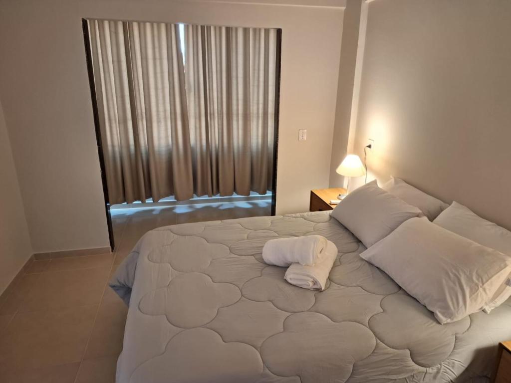 Ipê Suítes في دومينغوس مارتينز: سرير أبيض كبير في غرفة مع نافذة