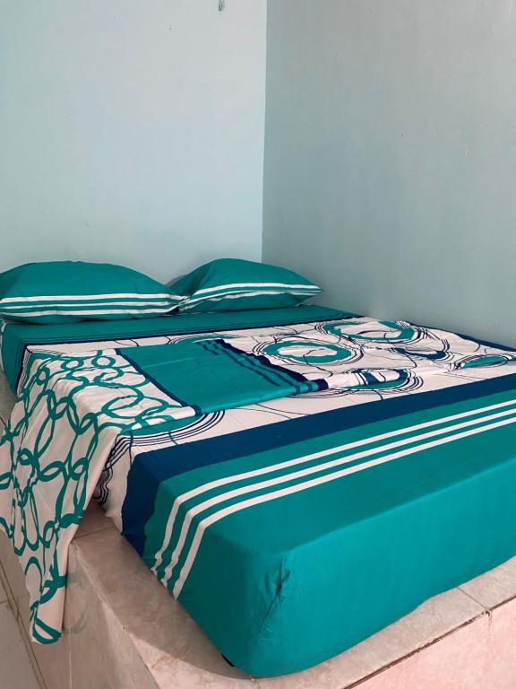 Cama con sábanas y almohadas azules y blancas en HOTEL casa VALLENATA en Valledupar