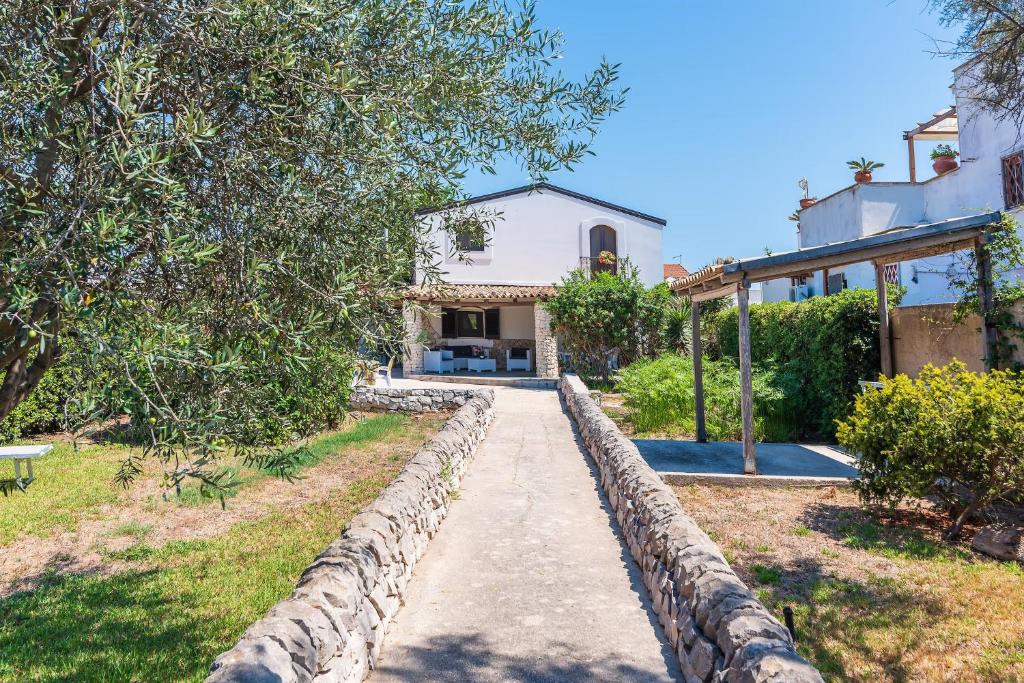 a house with a stone path leading to a house at Villa d'Eos - Granelli, Pachino in Granelli