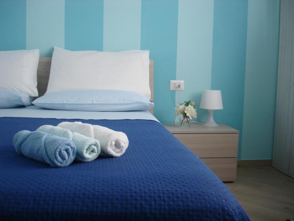 a bedroom with a blue bed with towels on it at B&B Margherita in Marina di Camerota