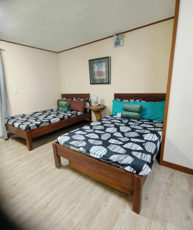 a bedroom with two beds and a couch at Studio Condo near Burnham in Baguio
